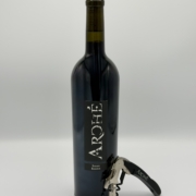 bottle of wine with corkscrew leaning against it.